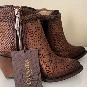 GENUINE BOVINE LEATHER
Perforated brown leather bootie with hand braided strap